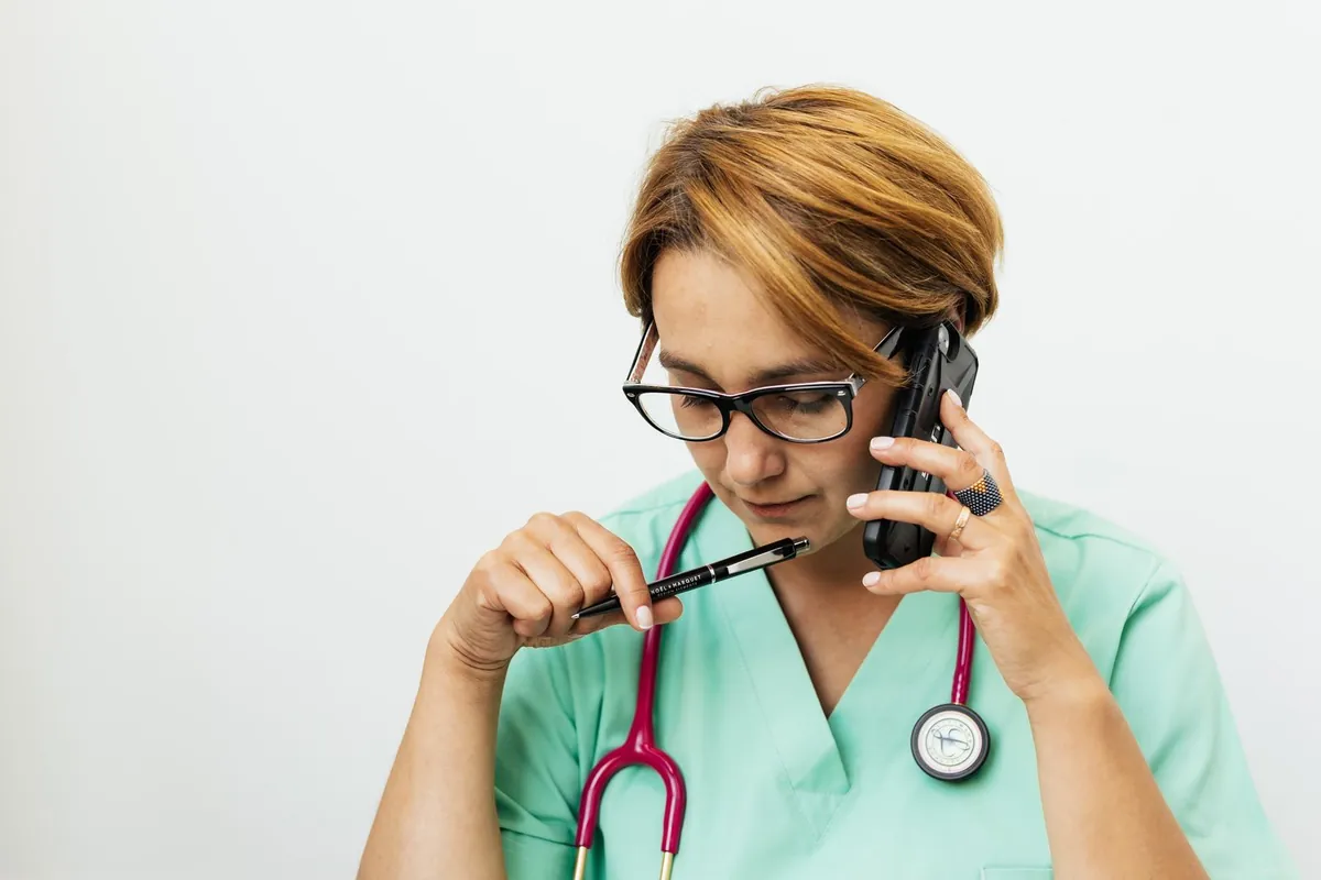 Médica atendiendo una consulta telefónica